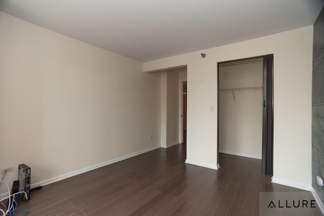 unfurnished bedroom featuring dark wood-type flooring, baseboards, and a closet