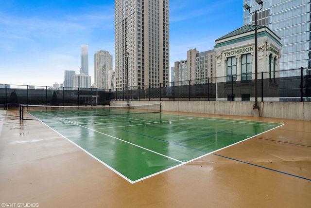 view of sport court featuring a view of city, community basketball court, and fence