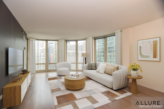 living area with a wall of windows, wood finished floors, and baseboards