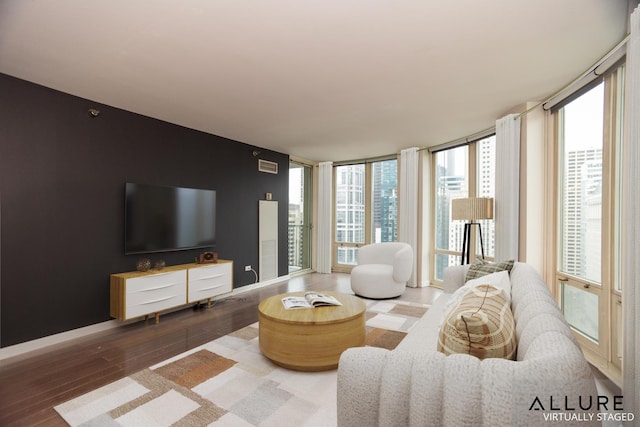 living area featuring expansive windows, baseboards, and wood finished floors