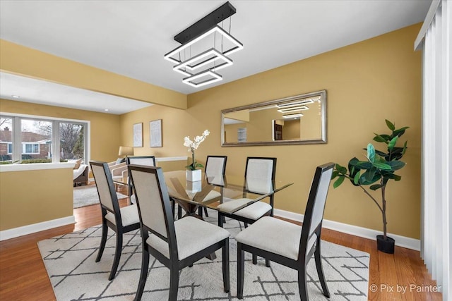 dining area with baseboards and wood finished floors