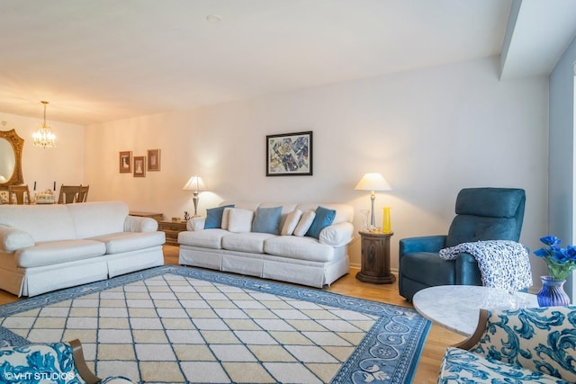 living area featuring baseboards, light wood-style floors, and an inviting chandelier