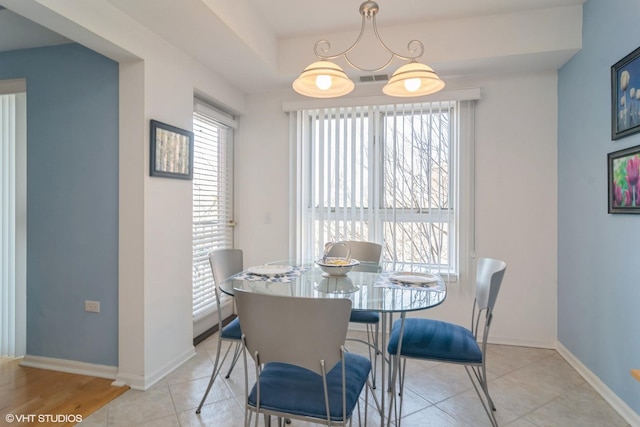 dining space featuring light tile patterned floors, visible vents, and baseboards