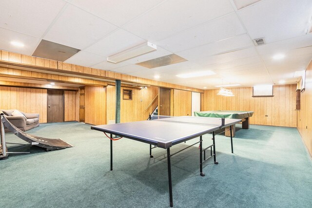 game room featuring visible vents, light colored carpet, a paneled ceiling, and wood walls