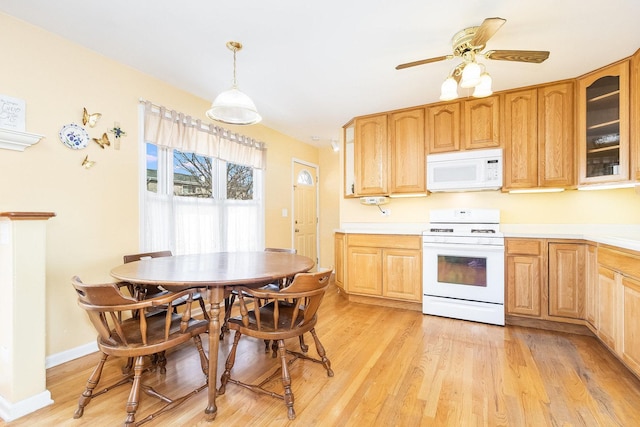 kitchen featuring light wood-type flooring, decorative light fixtures, white appliances, light countertops, and glass insert cabinets