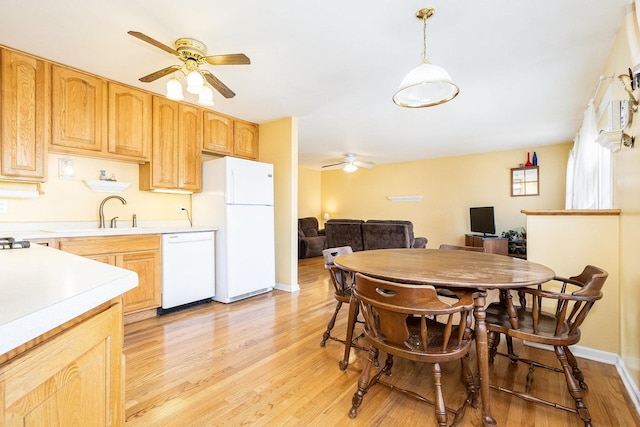 dining area featuring light wood-type flooring, baseboards, and a ceiling fan