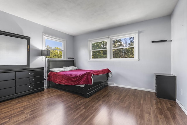 bedroom with wood finished floors and baseboards