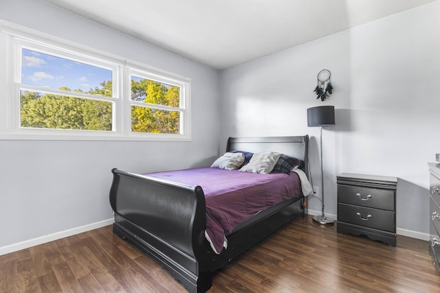 bedroom featuring baseboards and dark wood-style flooring