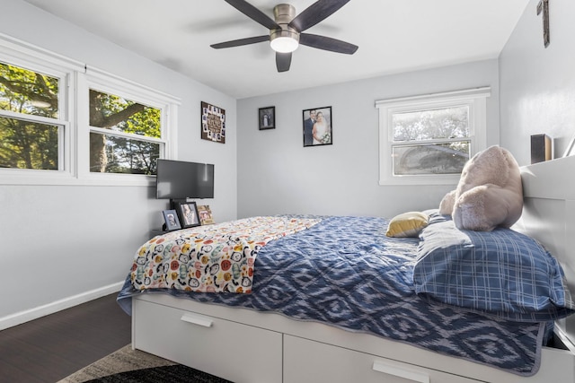 bedroom featuring baseboards, multiple windows, wood finished floors, and a ceiling fan