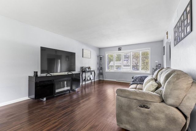 living room with a fireplace, wood finished floors, and baseboards