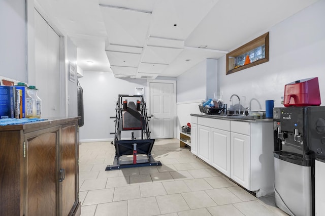 interior space featuring dark countertops, white cabinets, baseboards, and a sink