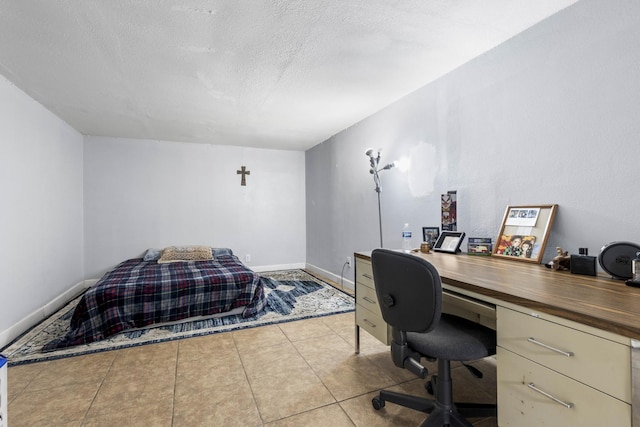 tiled bedroom featuring baseboards and a textured ceiling