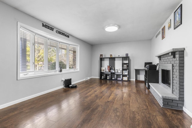 interior space featuring a fireplace, wood finished floors, and baseboards