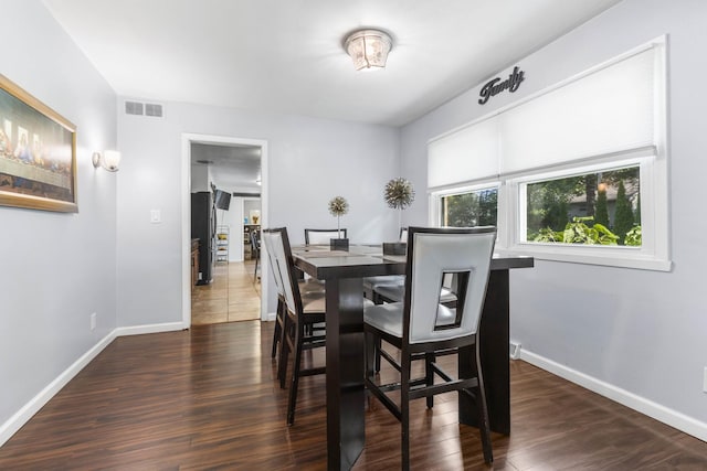 dining space featuring wood finished floors, visible vents, and baseboards