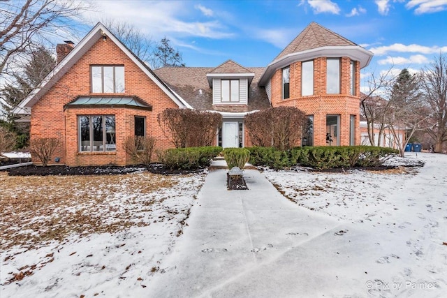 view of front of home featuring brick siding and a shingled roof