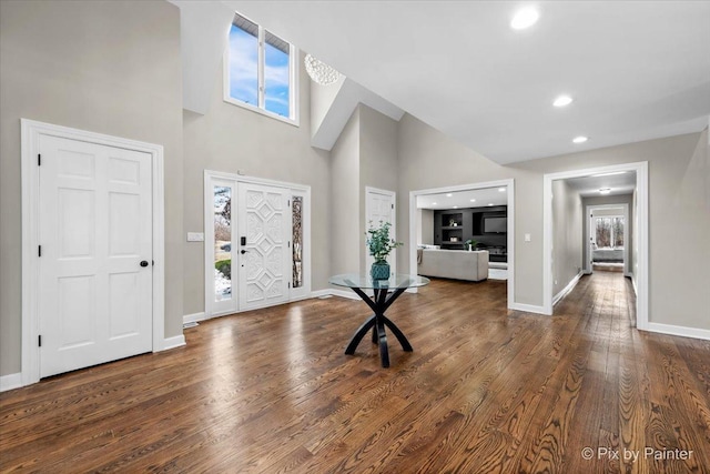 foyer entrance featuring recessed lighting, a high ceiling, baseboards, and wood finished floors