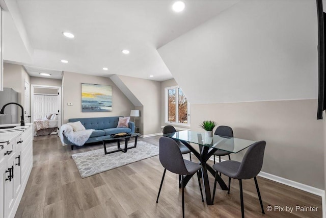 dining room featuring recessed lighting, baseboards, and light wood finished floors