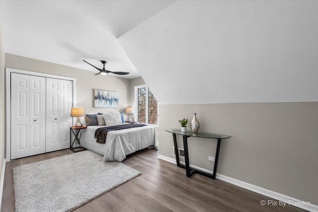 bedroom with a closet, baseboards, wood finished floors, and a ceiling fan