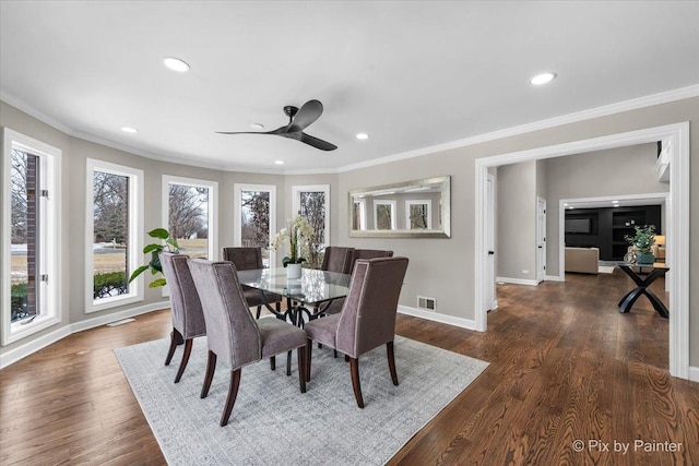 dining area with wood finished floors, crown molding, baseboards, and visible vents