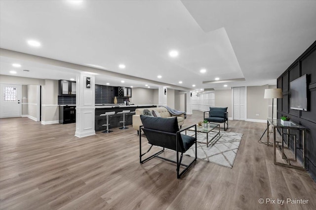 living area with recessed lighting, light wood-style floors, and baseboards