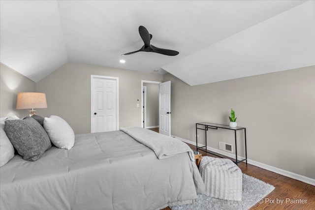 bedroom with lofted ceiling, wood finished floors, visible vents, and baseboards