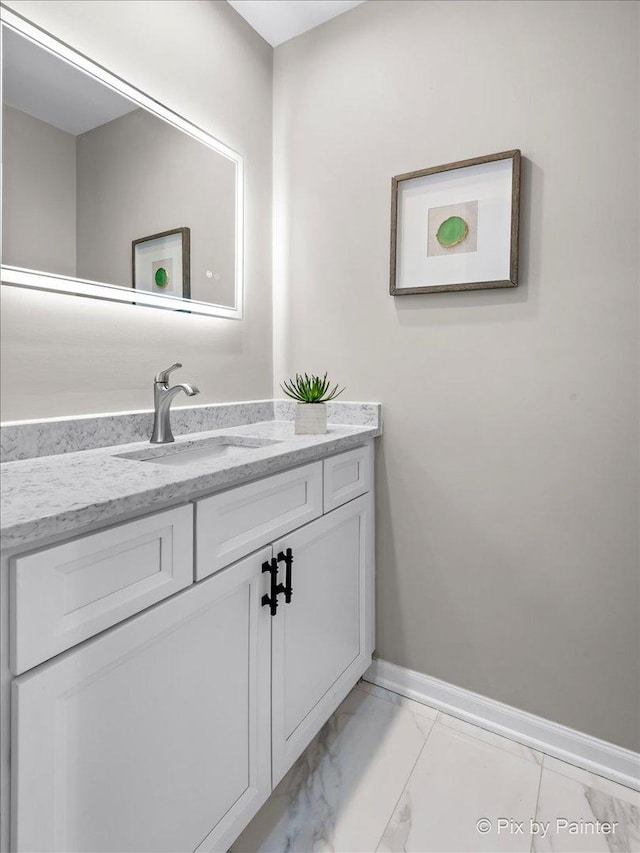 bathroom featuring vanity, baseboards, and marble finish floor