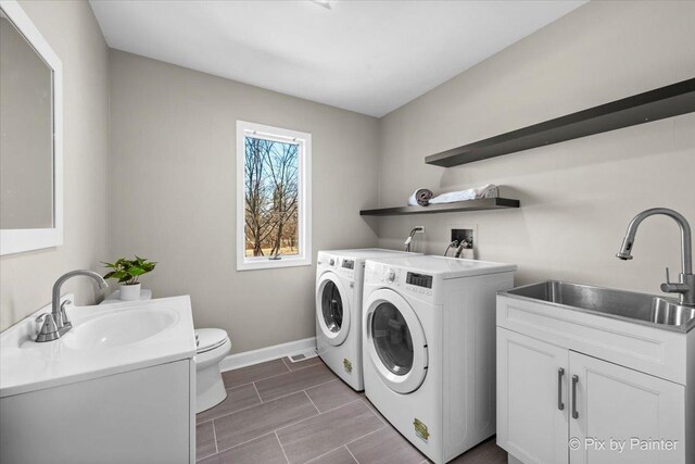 laundry room featuring a sink, baseboards, laundry area, and washer and dryer