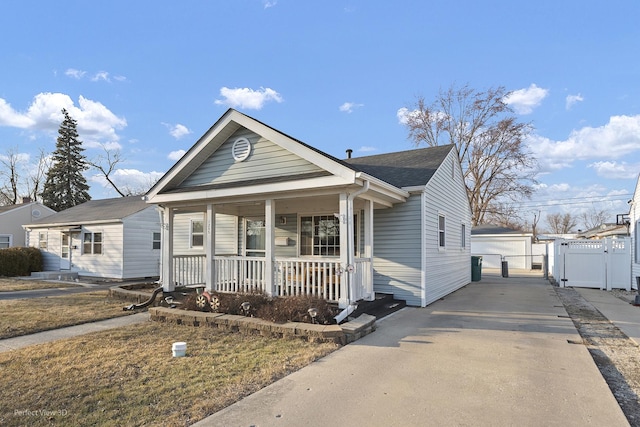 view of front of property featuring a gate, a porch, fence, a shingled roof, and a garage