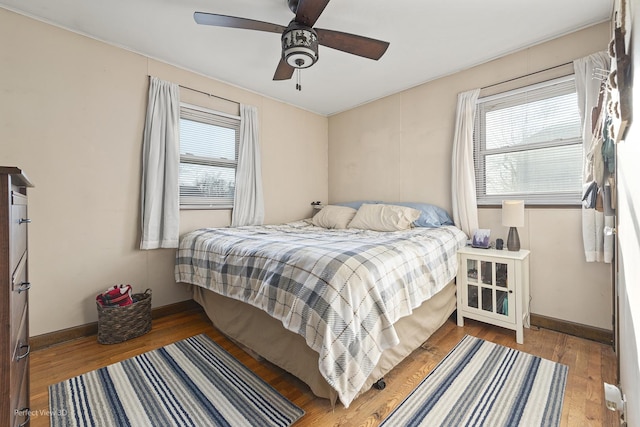 bedroom featuring ceiling fan, baseboards, and hardwood / wood-style flooring