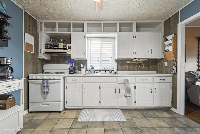 kitchen with a sink, white range with gas stovetop, under cabinet range hood, and white cabinets