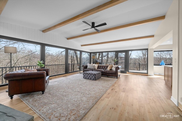 living area featuring beam ceiling, wood finished floors, and a ceiling fan