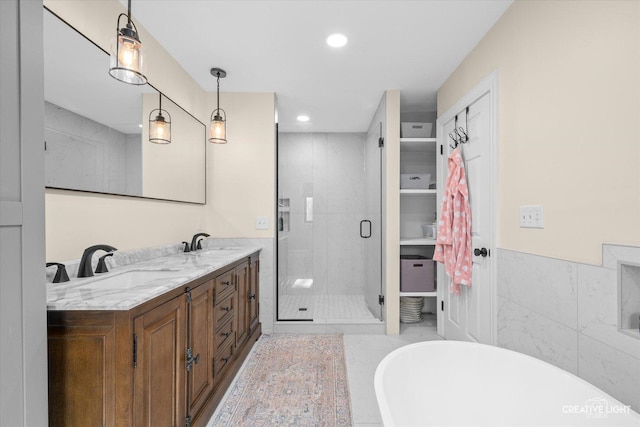 full bath with a sink, a freestanding tub, a stall shower, and double vanity