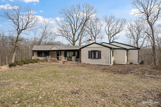 mid-century inspired home with brick siding and a chimney