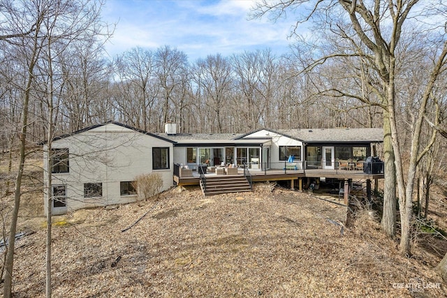 rear view of house featuring a wooden deck and a chimney