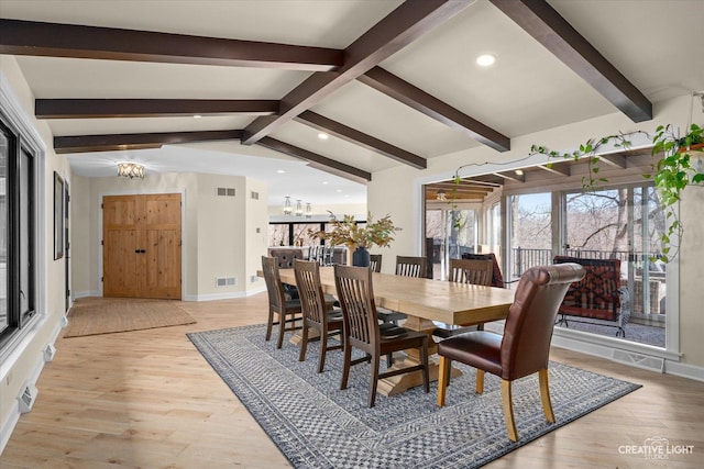 dining area featuring light wood finished floors, visible vents, vaulted ceiling with beams, and a notable chandelier