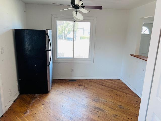 kitchen featuring baseboards, freestanding refrigerator, ceiling fan, and hardwood / wood-style flooring