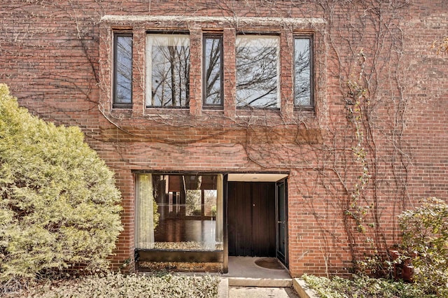 view of exterior entry featuring brick siding