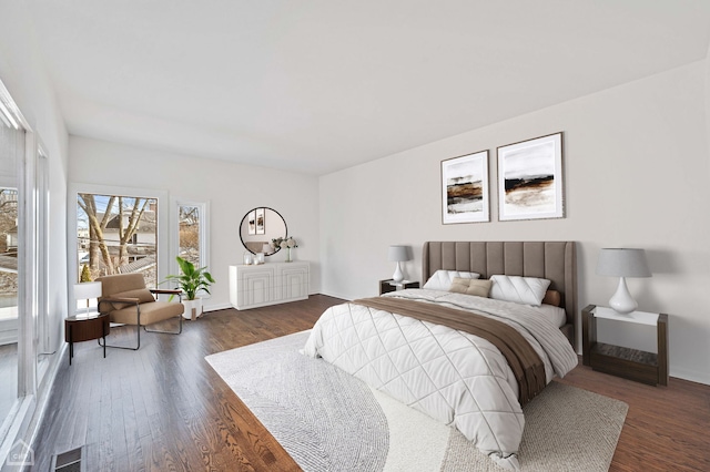 bedroom featuring visible vents, baseboards, and dark wood finished floors