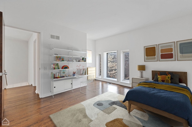 bedroom featuring visible vents, baseboards, and wood finished floors