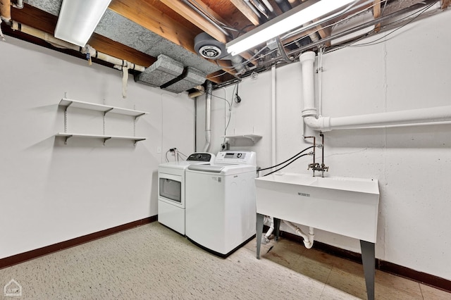 washroom featuring laundry area, washing machine and dryer, and baseboards