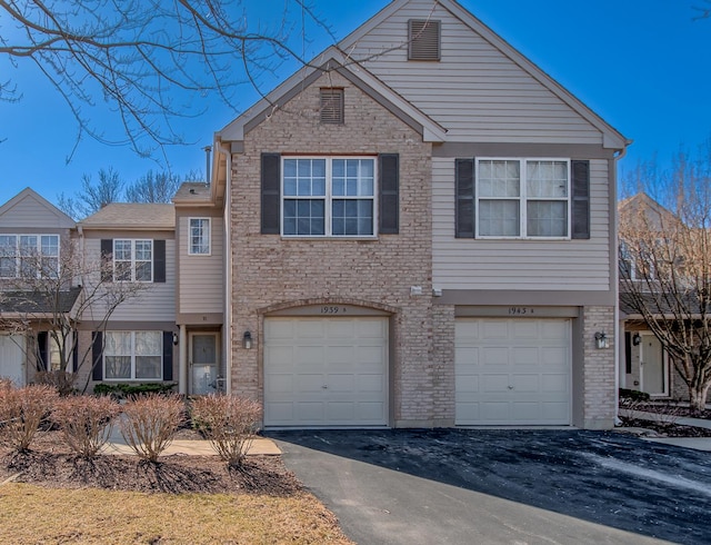 view of front of home featuring a garage, brick siding, and driveway