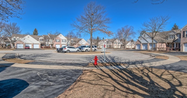 view of street featuring sidewalks, a residential view, and street lights