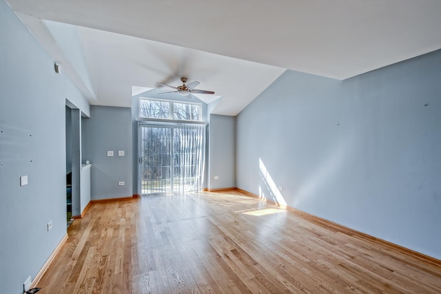 spare room featuring baseboards, light wood-type flooring, ceiling fan, and vaulted ceiling