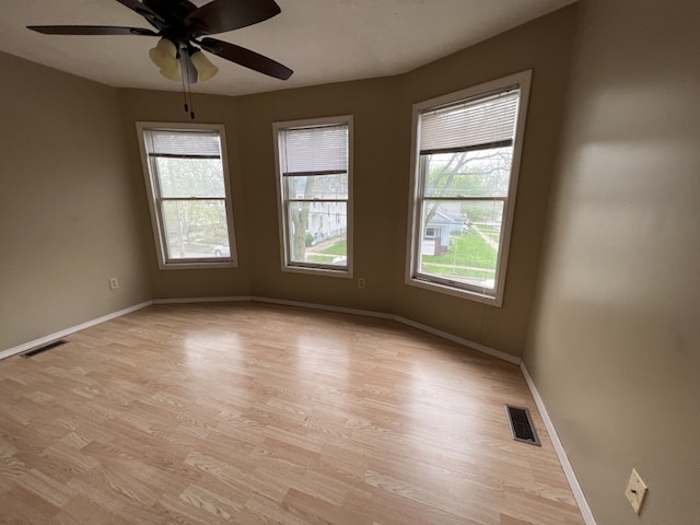 empty room with visible vents, baseboards, and light wood-style floors