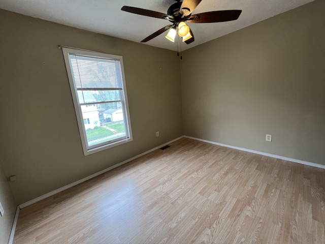 empty room featuring visible vents, light wood-style floors, baseboards, and ceiling fan