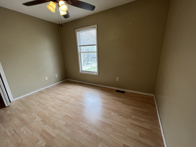 empty room featuring visible vents, baseboards, light wood-style floors, and a ceiling fan