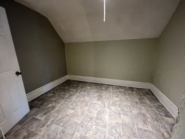 additional living space with lofted ceiling and baseboards