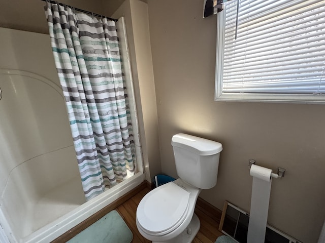 full bath featuring toilet, a shower with curtain, and wood finished floors