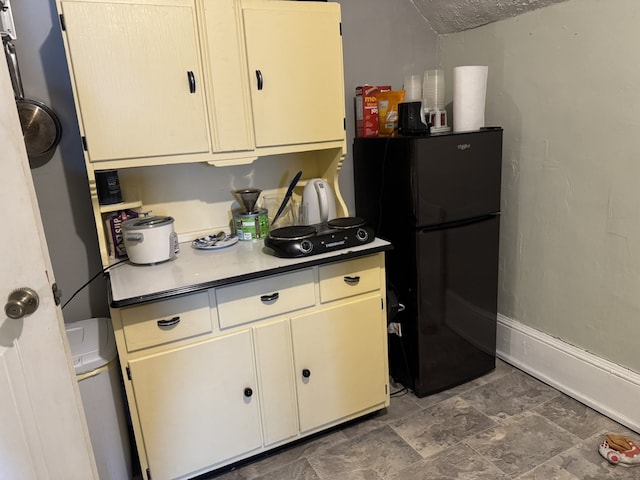 kitchen with baseboards and freestanding refrigerator