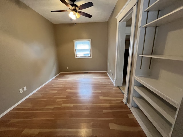 unfurnished bedroom featuring a ceiling fan, wood finished floors, and baseboards